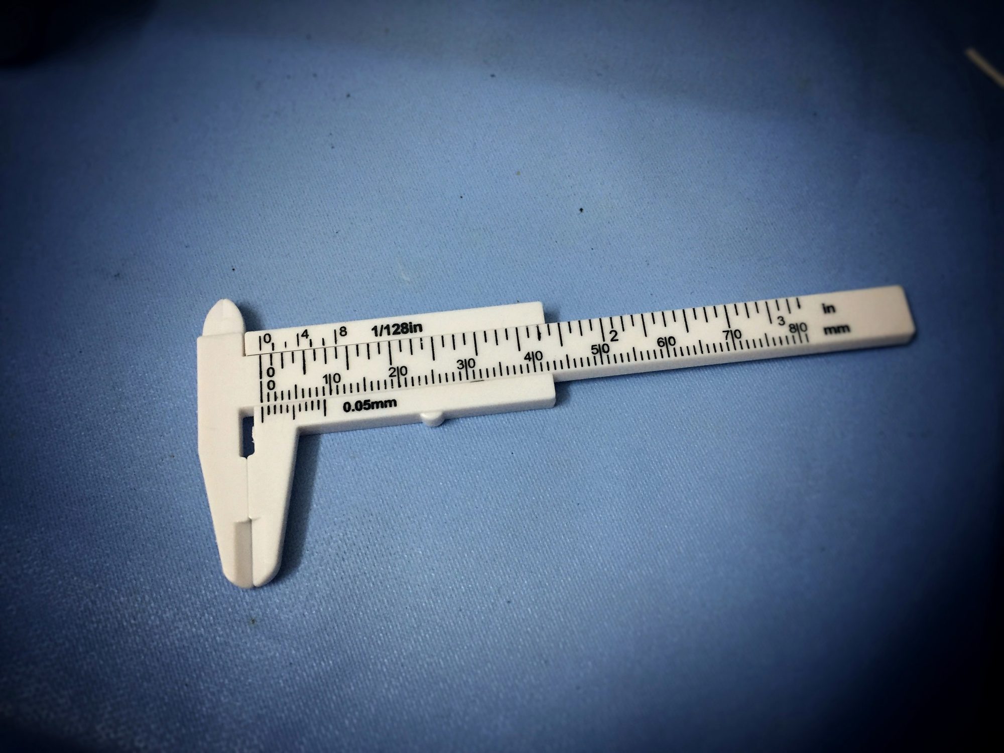 A vernier caliper on a blue surface