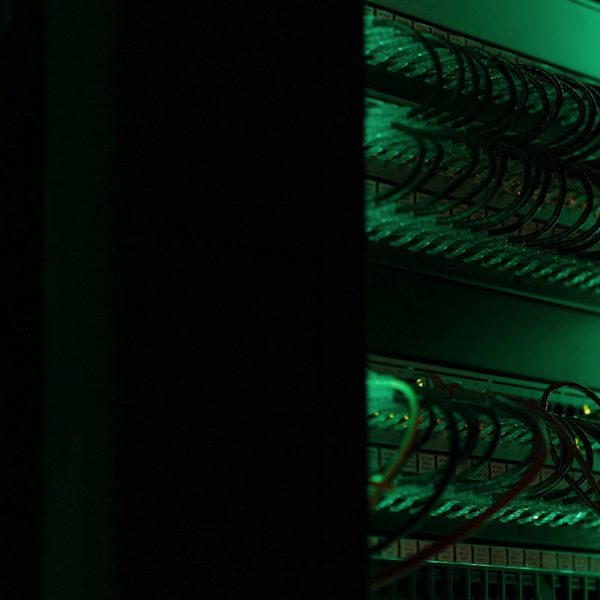 Server racks glowing green in a dark room