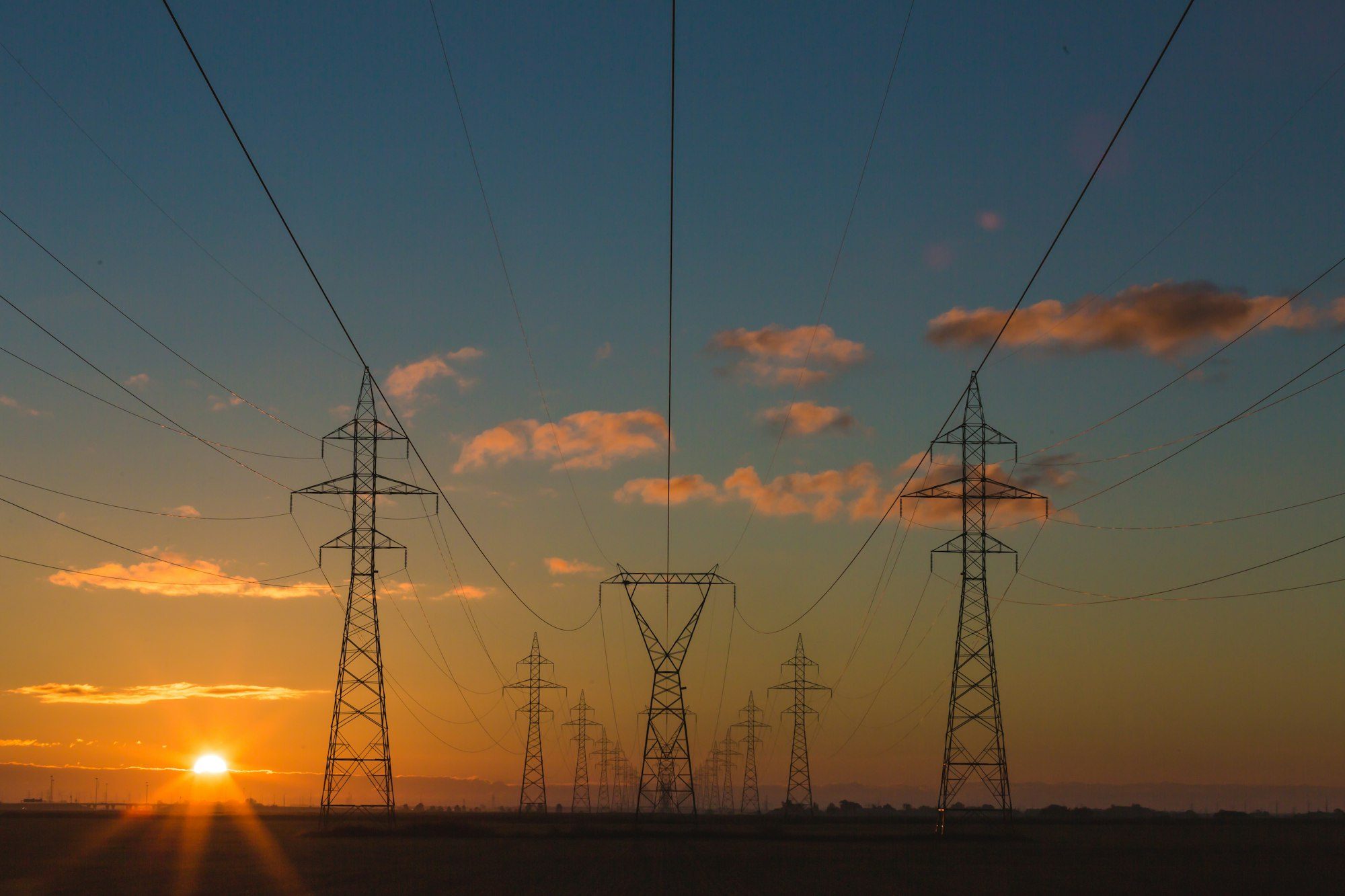 High-voltage transmission lines at sunset